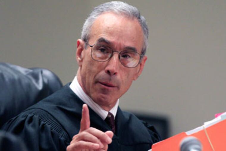 Judge Glenn Berman holds a folder of letters as he gives instructions during a sentencing hearing for Dharun Ravi in New Brunswick, N.J., Monday, May 21, 2012. Ravi, a former Rutgers University student who used a webcam to watch his roommate kiss another man days before the roommate killed himself, was sentenced Monday to 30 days in jail and three years of probation. Judge Berman said he would not recommend Ravi be deported to India, where he was born and remains a citizen. But Ravi was ordered to get counseling and to pay $10,000 that would go to a program to help victims of bias crimes. (AP Photo/Mel†Evans)