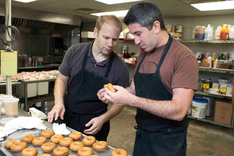 Owners Steve Cook (left) and Michael Solomonov check the consistency of a batch of lime custard-filled doughnuts for Federal Donuts.