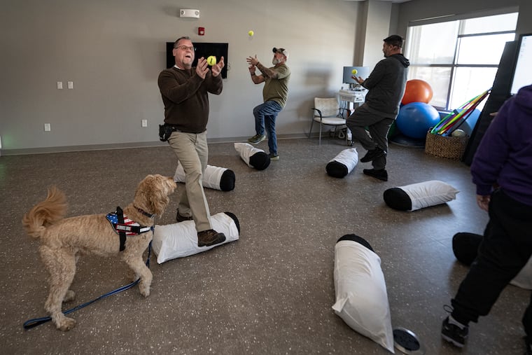 Army veteran Scott Edgell participates in a cohort session with his therapy dog, Lars, at the MossRehab Institute for Brain Health.