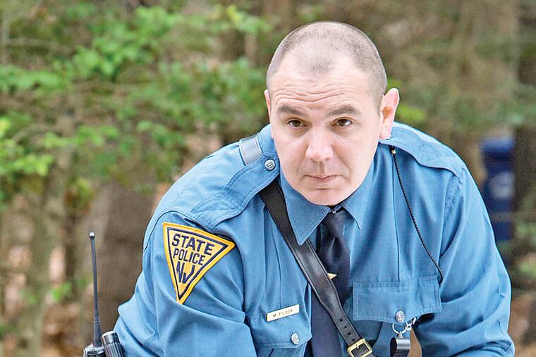 A New Jersey state trooper secures a police line Thursday, Nov. 20, 2014 in the Tabernacle Twp. neighborhood in New Jersey. New Jersey State Police are investigating a multiple shooting where at least two people died. (Ed Hille/Philadelphia Inquirer/TNS)
