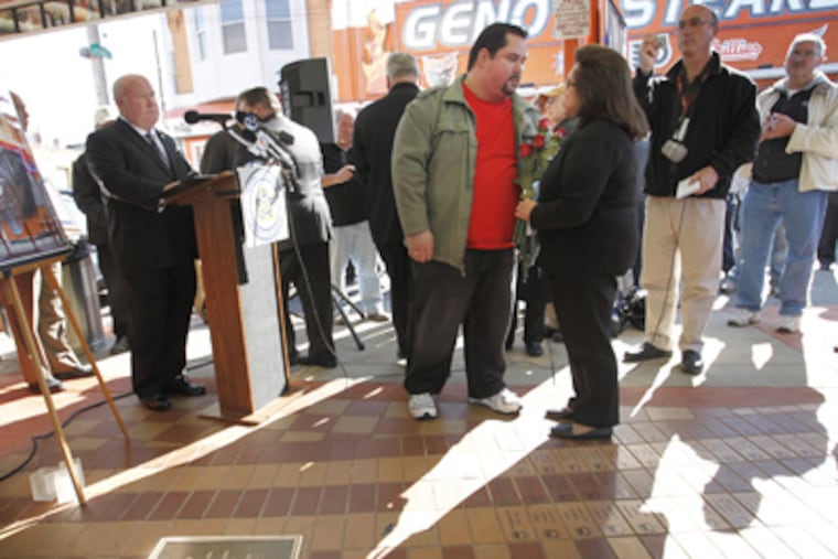 After the Fraternal Order of Police unveils a plaque dedicated to Joey Vento outside his eatery, Geno’s Steaks, his son, Geno, and his widow, Eileen, share a moment. (Alejandro A. Alvarez / Staff Photographer)
