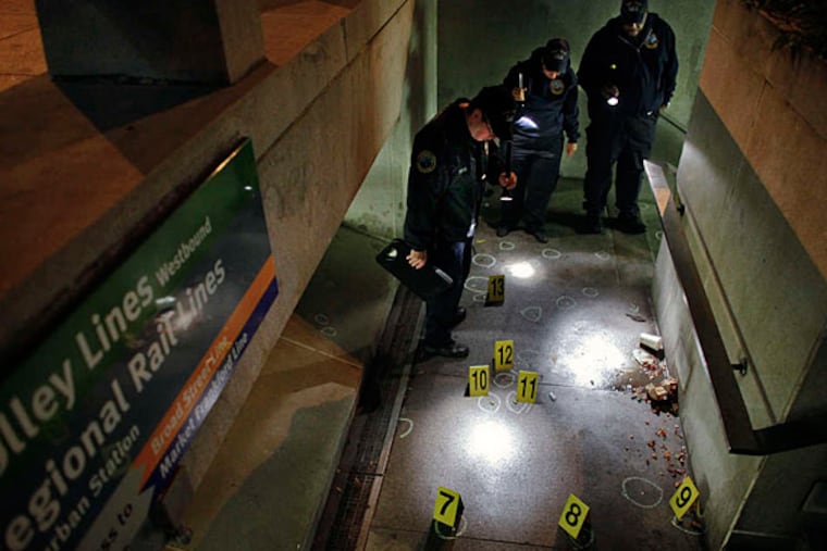 Philadelphia police officers look over the scene at 15th and JFK where 38-year-old man was killed in October 2013. A Philly homicide police lieutenant leads the city in overtime pay. (Joseph Kaczmarek/Staff/File)