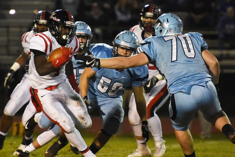 Coatesville's Aaron Young, runs past several North Penn defenders in a District 1 Class 6A semifinal in 2016 The Knights triumphed, 42-25.