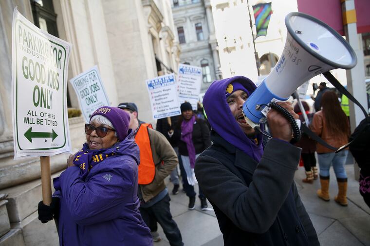 Service Employees International Union field representative Marcus Garland, right, and other members of SEIU Local 32BJ protest in support of parking attendants outside the Ritz-Carlton Hotel in Center City Philadelphia on Saturday, Feb. 9, 2019. City Council just passed two bills that aim to protect the low-wage workers' jobs and improve working conditions.