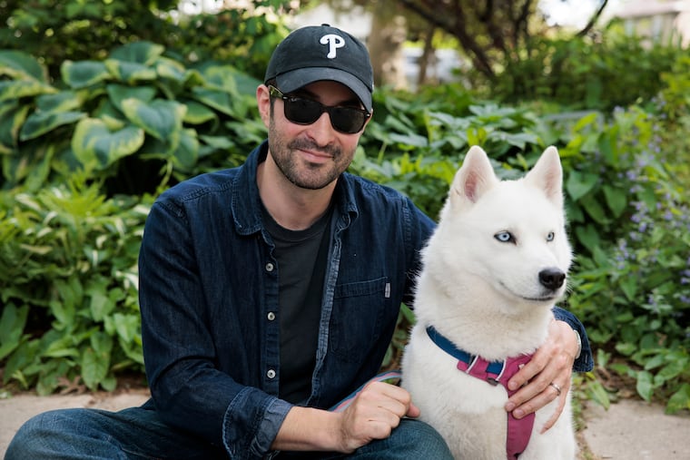 Elias Weiss Friedman, photographer and founder of The Dogist, posed for a portrait with his dog named Elsa in his childhood neighborhood on May in Narberth.