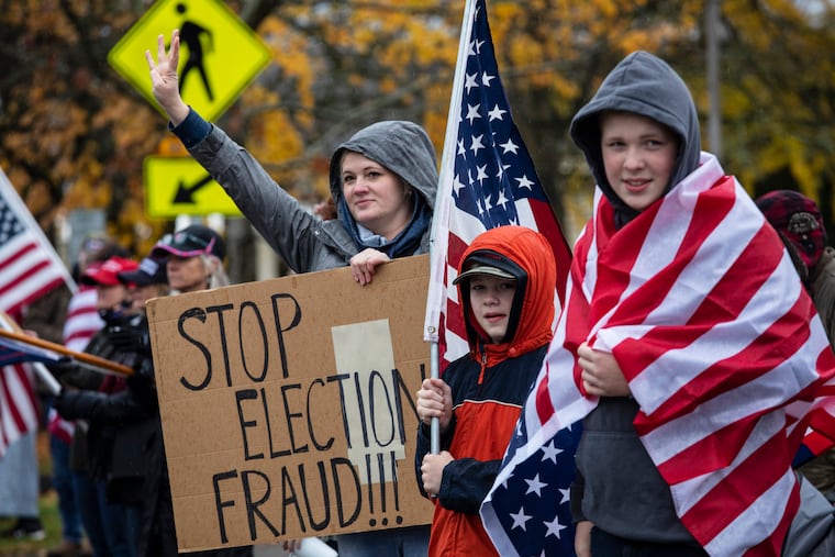 Supporters of President Donald Trump hold signs as they attend a 2020 "Stop The Steal" rally, protesting the outcome of the presidential election, at the Oregon State Capitol, in Salem, Ore.