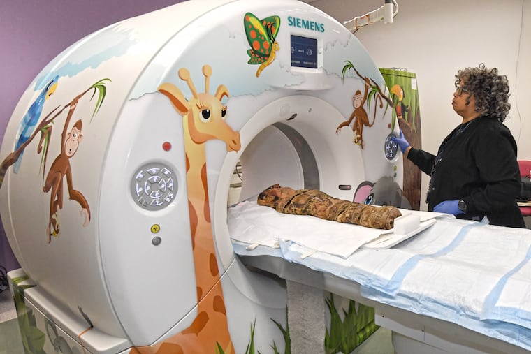 Felicia Williams, a technician in radiology at Children's Hospital of Philadelphia (CHOP) positions a 2,000-year-old child mummy for a CT, or "cat scan," on Sunday morning. A mummy obtained by the University of Pennsylvania Museum of Archaeology and Anthropology goes through a CT scan test at the Children's Hospital of Philadelphia. Sunday, October 7, 2018. The mummy is assumed to be a girl that lived around 270-280 CE during the Roman period in Egypt. The scans will be used to create a 3-D model for researchers to further investigate.