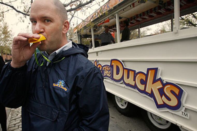 Chris Herschend, president of Ride the Ducks amphibious tour boats, gives a quack with a handout plastic quacker along North 5th Street, where the company boards passengers. (Alejandro A. Alvarez / Staff Photographer)