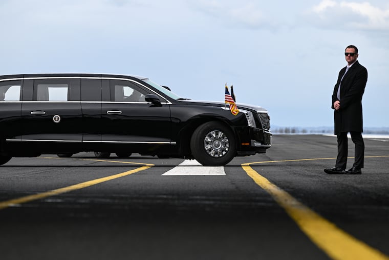 A Secret Service Agent stands next to a vehicle in President Joe Biden’s motorcade at RAF Aldergrove in Antrim, Northern Ireland, April 12, 2023. From horse-drawn presidential coaches to Air Force One, presidents have used various modes of transportation to project an image of America for nearly 250 years.