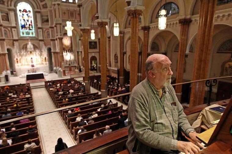 Nick Lyons plays the organ from the choir loft in St. Francis Xavier Church before a Mass on Sunday that aimed to bring people of the archdiocese together. By Mass time, Lyons had a much larger audience.