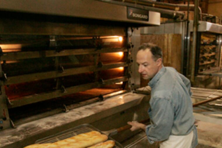 James Barrett of Metropolitan Bakery removes freshly baked baguettes from the hot oven.