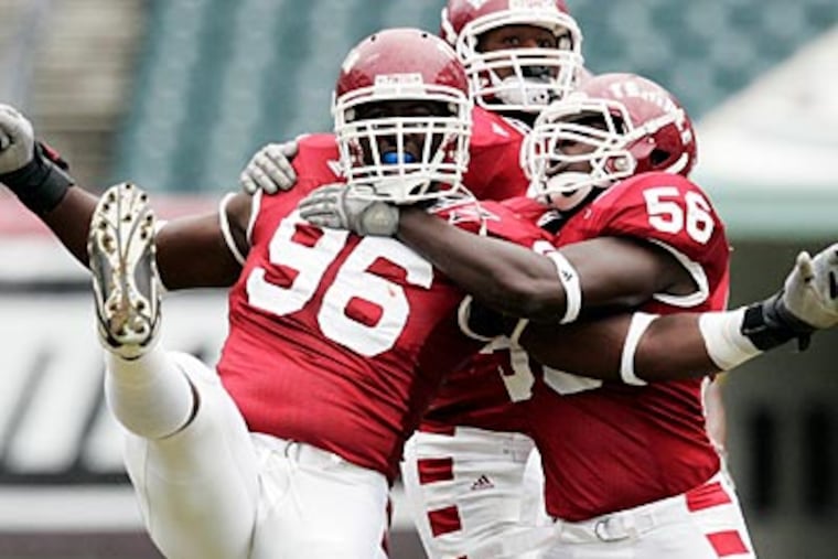 Amara Kamara (No. 56) and Muhammad Wilkerson (No. 96) celebrate a sack against Army last fall. (AP Photo / Tom Mihalek)