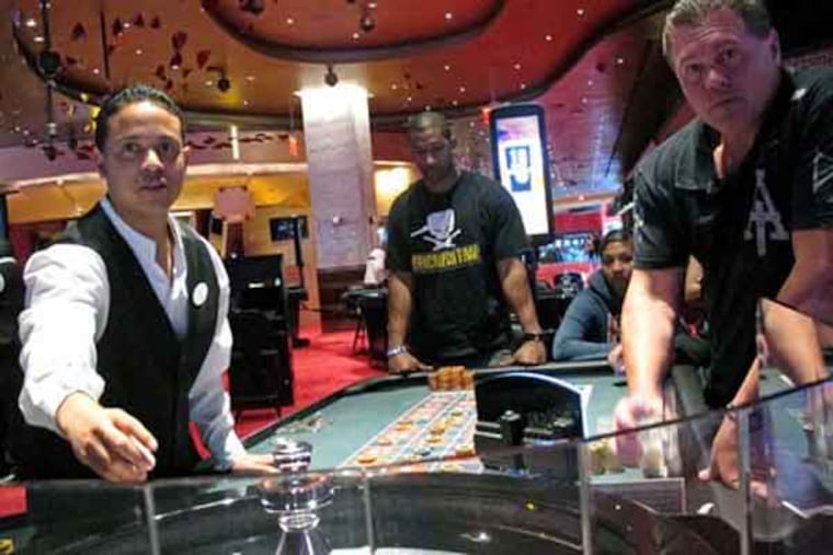 FILE - In this May 21, 2012 file photo, a dealer at Revel prepares for another round of roulette at the Atlantic City, N.J., casino as patrons await the result. Commercial casinos in the U.S. have made it almost all the way back from the hard times of the Great Recession. The American Gaming Association says revenue at non-Indian casinos hit $37.3 billion last year, just a shade under the all-time high reached in 2007. However, New Jersey experienced the largest decline in casino revenue, despite adding a 12th casino, Revel, which filed for Chapter 11 bankruptcy protection after less than a year of operation. Furthermore, Atlantic City’s casinos were hurt by the after-effects of Superstorm Sandy, which kept many visitors away from months after the Oct. 29 storm. (AP Photo/Wayne Parry, File)