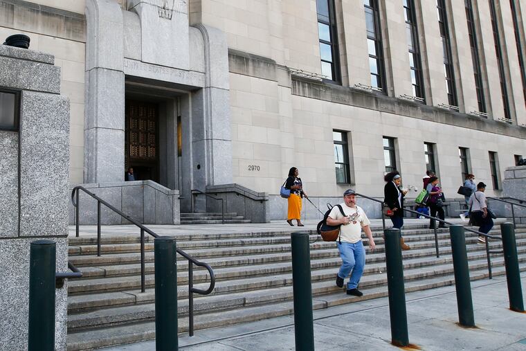 IRS workers leave the University City building along Market Street in March 2020.