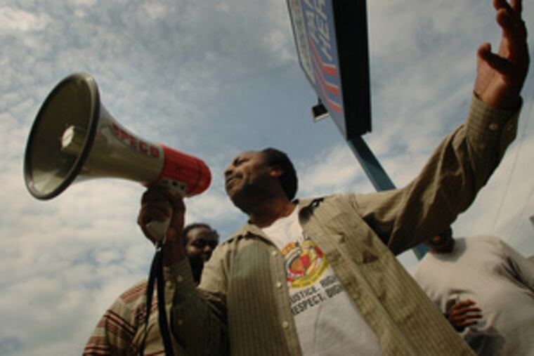 A cabbie addresses about two dozen supporters outside Philadelphia Parking Authority headquarters. Taxi and city officials disputed the number of cabbies who went on strike.