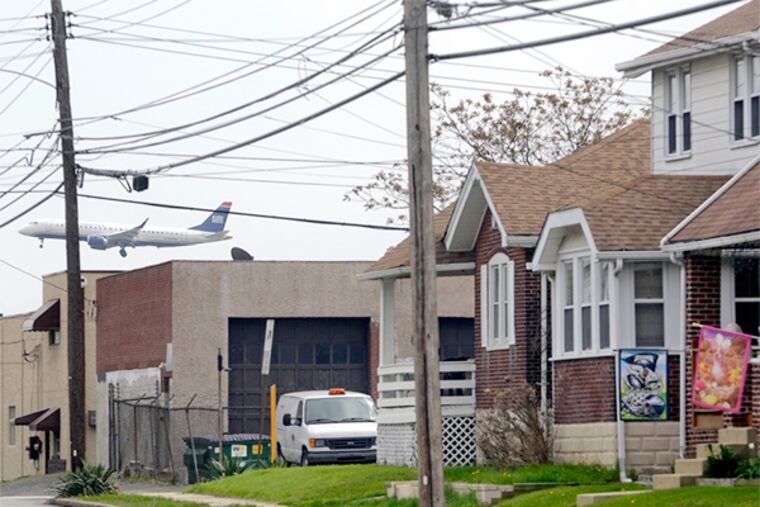 A passenger airliner lands at Philadelphia International Airport over 4th Avenue.