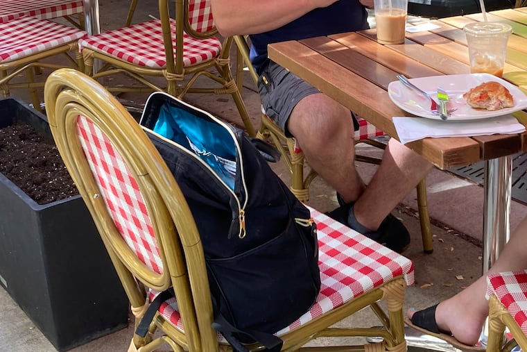 An unzipped bag on a restaurant chair is never a good idea.