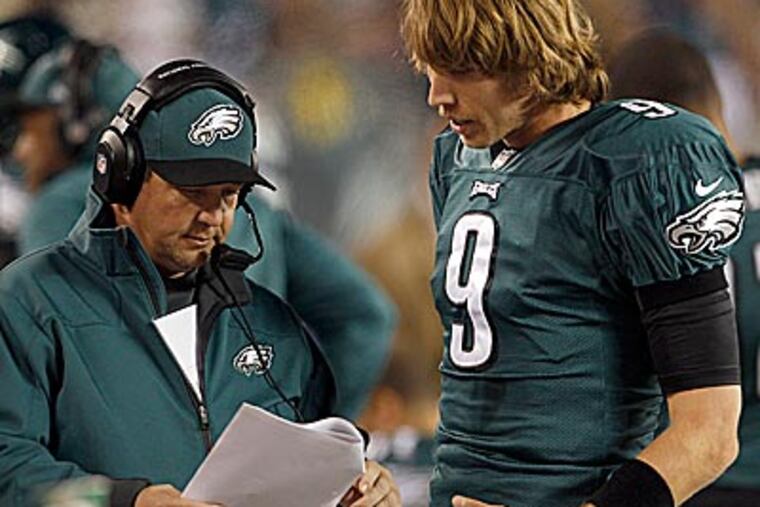 Eagles quarterback Nick Foles and offensive coordinator Marty Mornhinweg talk over plays on the sidelines. (Yong Kim/Staff Photographer)