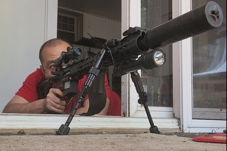 In a picture obtained by investigators, Tony Ho is seen firing a homemade ghost gun and silencer into his backyard in Hatfield. Ho has been charged with manufacturing and selling at least 15 unregistered ghost guns.