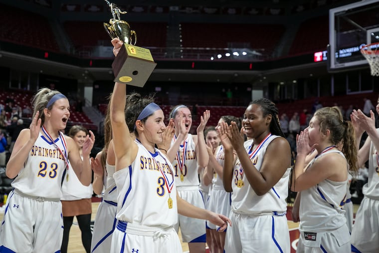 Springfield-Delco senior Alyssa Long hoists the trophy after her team defeated Great Valley, 29-27, in the District 1 Class 5A girls basketball championship game on Saturday.