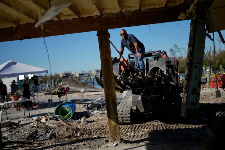 A contractor straightens a support post at Getaway Marina in Fort Myers Beach, Fla., on Sunday.