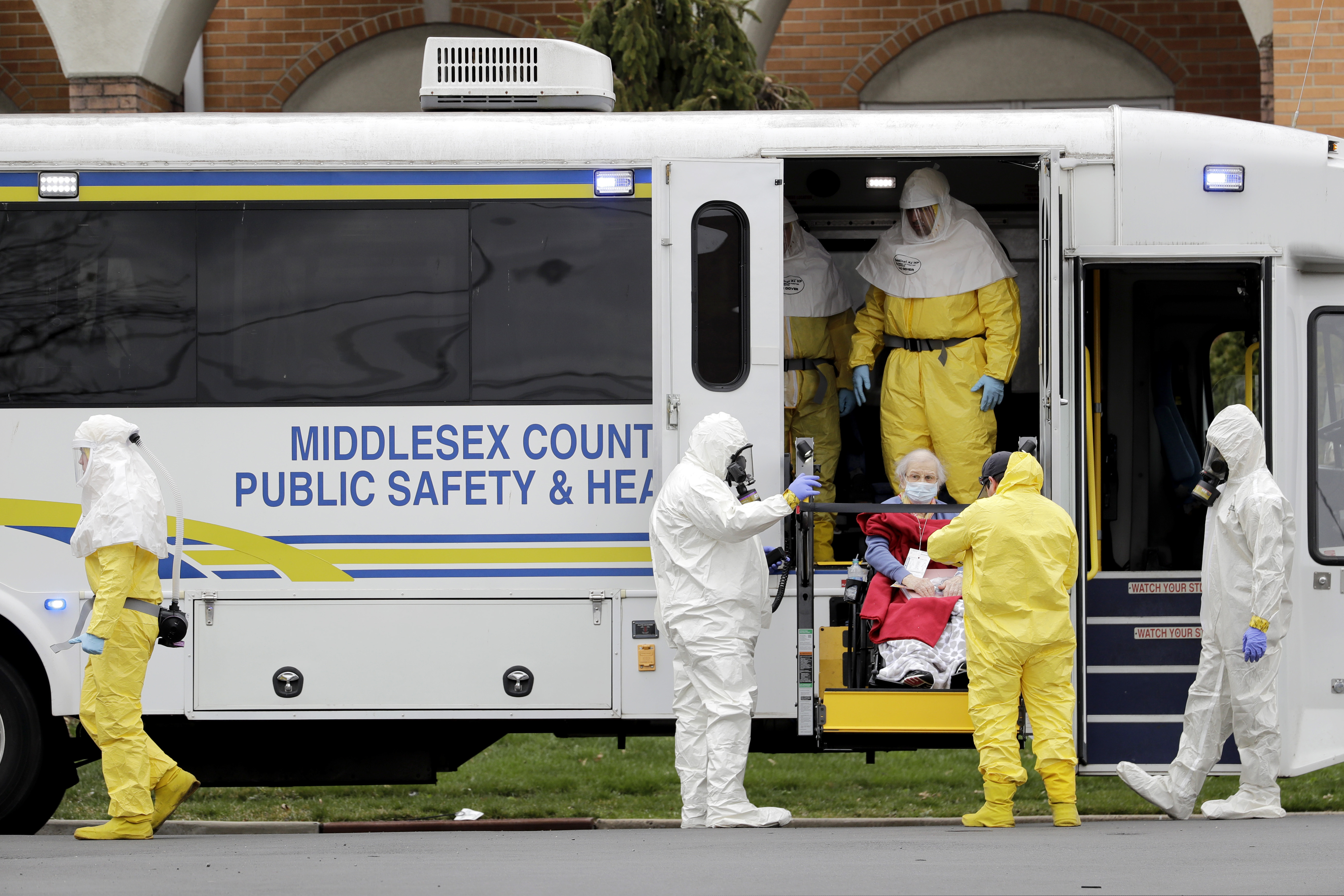 Residents from St. Joseph's Senior Home are helped onto buses in Woodbridge, N.J., Wednesday, March 25. More than 90 residents of the nursing home were transferred to a facility in Whippany after 24 tested positive for COVID-19, according to a spokeswoman for CareOne, which operates the facility.