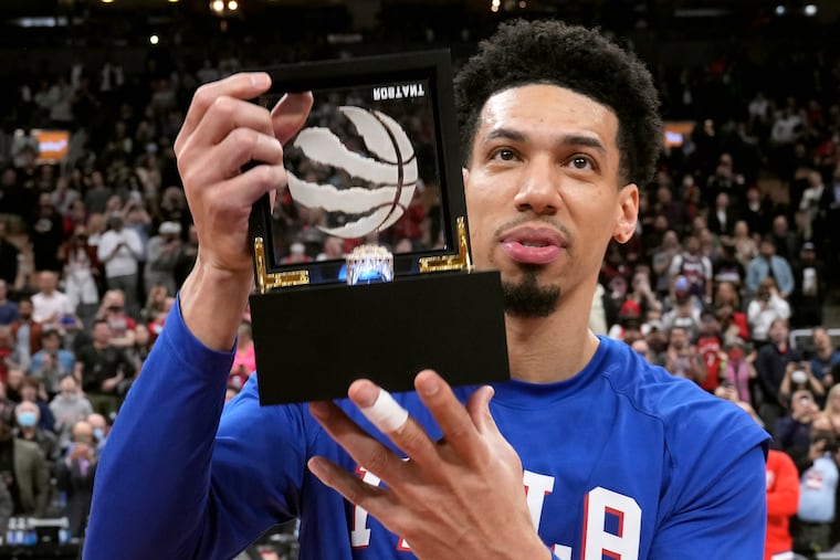 Philadelphia 76ers' Danny Green, who was a Toronto Raptor when the team won the 2019 NBA title, shows off his championship ring to the crowd during a presentation ceremony before an NBA basketball game Thursday, April 7, 2022, in Toronto. (Frank Gunn/The Canadian Press via AP)