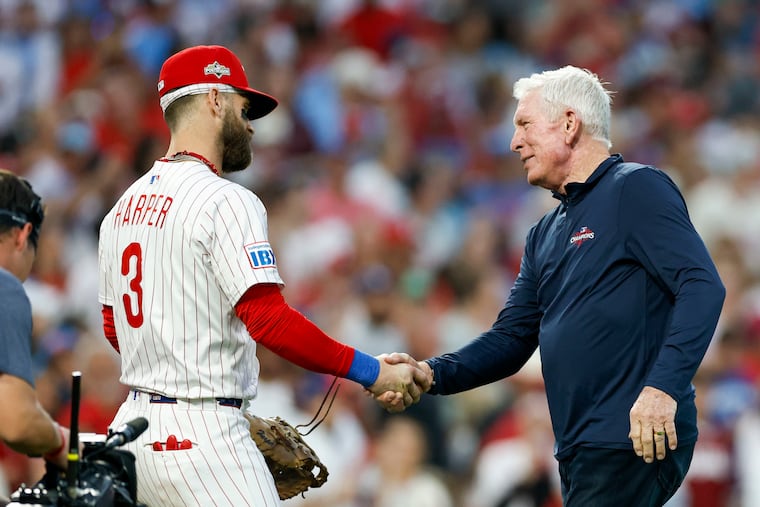 Phillies Hall of Famer Mike Schmidt shakes hands with Bryce Harper after Schmidt threw out the first pitch before Game 1 of the NLDS against the Dodgers on Oct. 4.