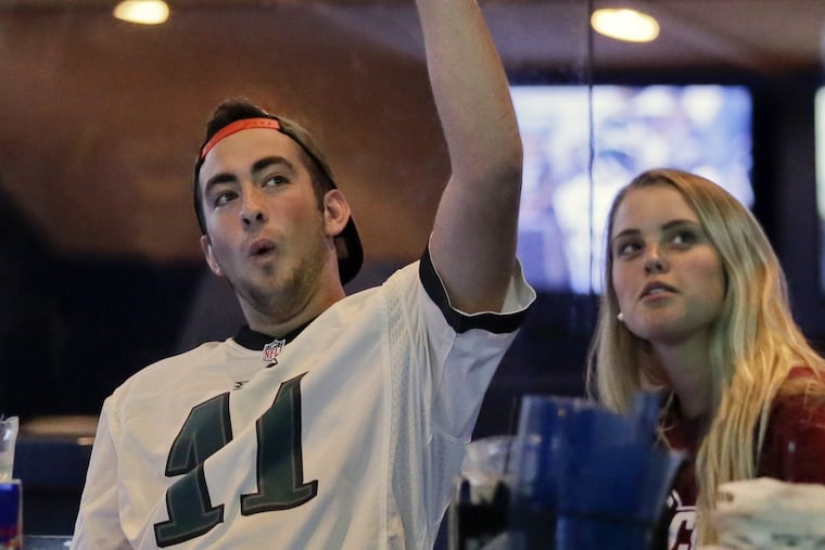 Keith McDonald of Millersville, Pa. and Tabitha Evans of Landisville, Pa. (formerly from Collegeville) cheer for an Eagles touchdown while watching the Dolphins-Eagles preseason game at Arooga’s Grille House & Sports Bar in Lancaster.