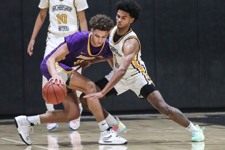 Roman Catholic Daniel Skillings, 0, left, tries to keep the ball from Archbishop Wood Justin Moore 1, during the 1st quarter in Warminster, Wednesday, January 12, 2022.