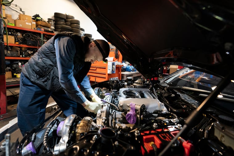 Mechanic David Stoliaruk works on the engine of a car at IC Auto in Philadelphia earlier this year.
