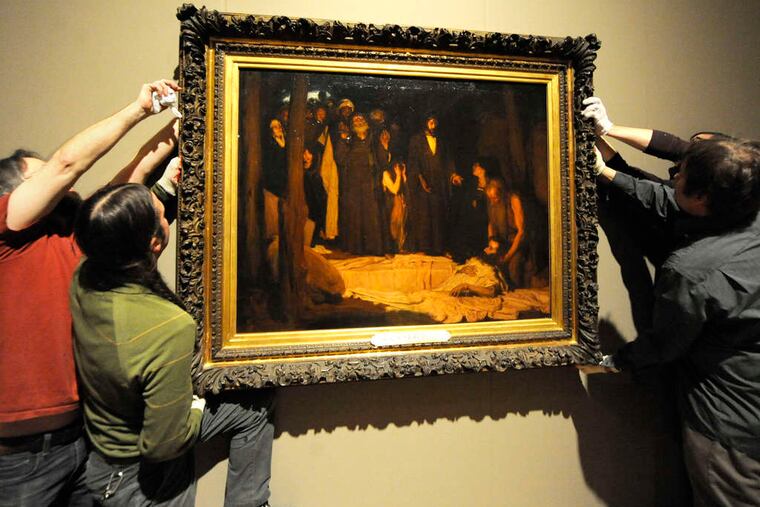 Pennsylvania Academy of Fine Arts staffers hang Tanner's "The Resurrection of Lazarus" on the gallery wall in preparation for the Tanner exhibition, which runs from Saturday to April 15.