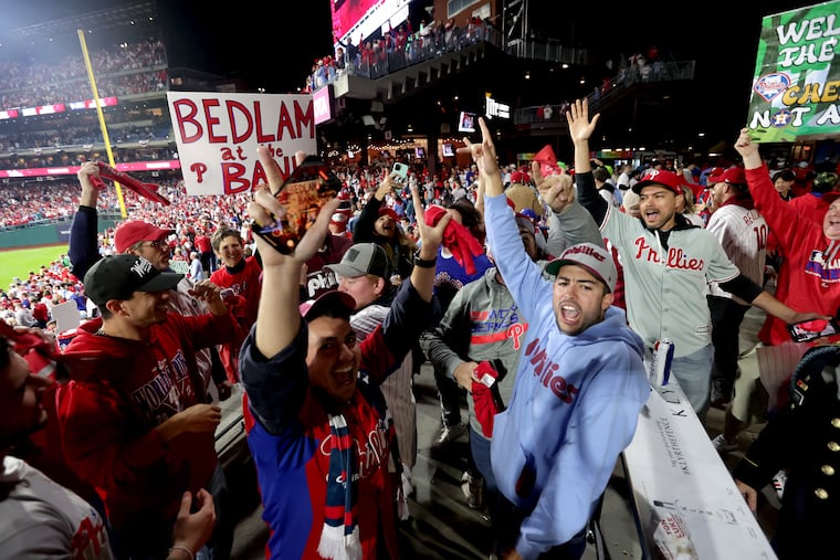 With a "Bedlam at the Bank" sign in the background, Phillies fans celebrate winning Game 4 of the 2022 World Series against the Astros.