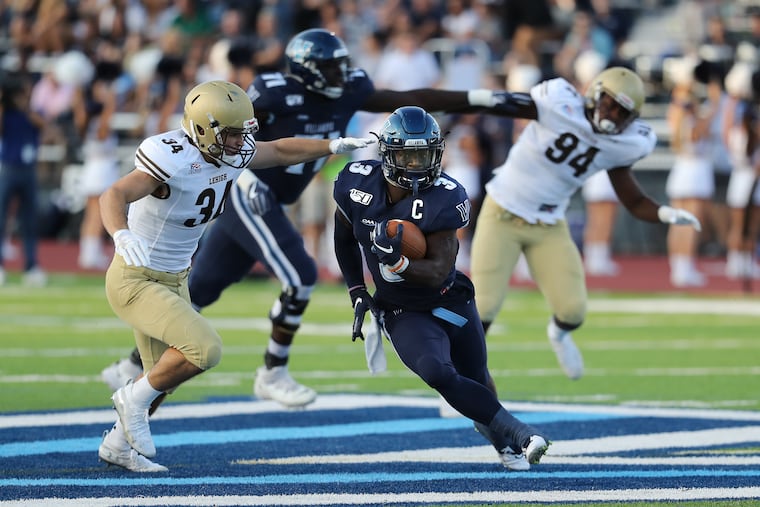 Justin Covington, center, of Villanova avoiding Pete Haffner of Lehigh for a long gain on Sept. 7.