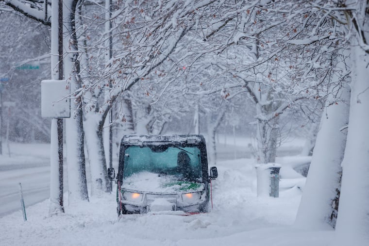 A small plow vehicle pushes its way through the snow along Kelly Drive in Philadelphia Monday.