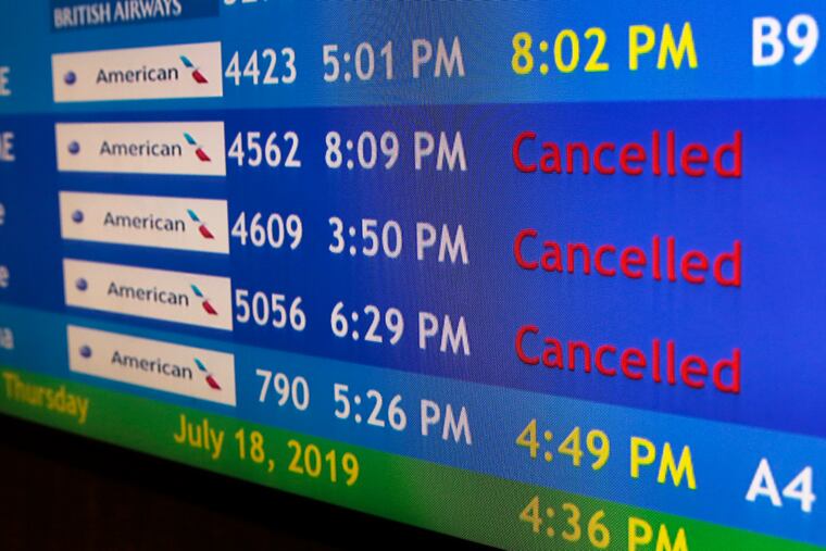 The flight information display screens at Philadelphia International Airport show cancelled American Airlines flights on July 18.