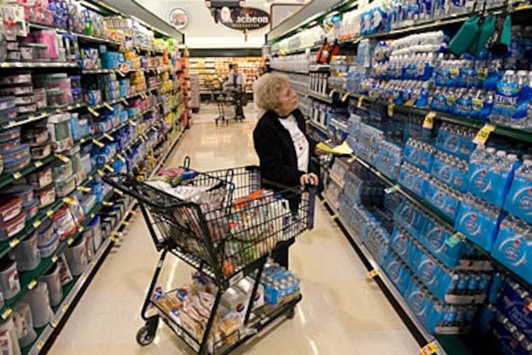 At a Harris Teeter grocery store in North Carolina, Betty Dean comparison-shops for bottled water. To hold down grocery bills, she uses coupons her husband clips. (Shawn Rocco / Raleigh News & Observer)