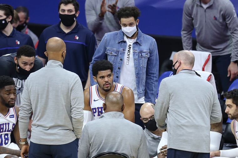 Sixers' Seth Curry (center) watches his team during a timeout against the Celtics during the first quarter at the Wells Fargo Center on Wednesday.