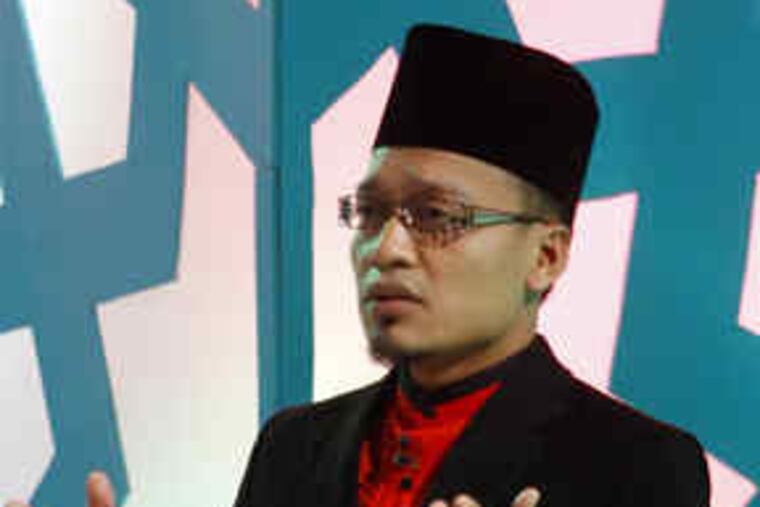 During taping of the reality-TV show "Imam Muda" or "Young Leader," chief judge Hasan Mahmud al-Hafiz, left, addresses the audience. At right is one of the contestants, Taufek Noh.