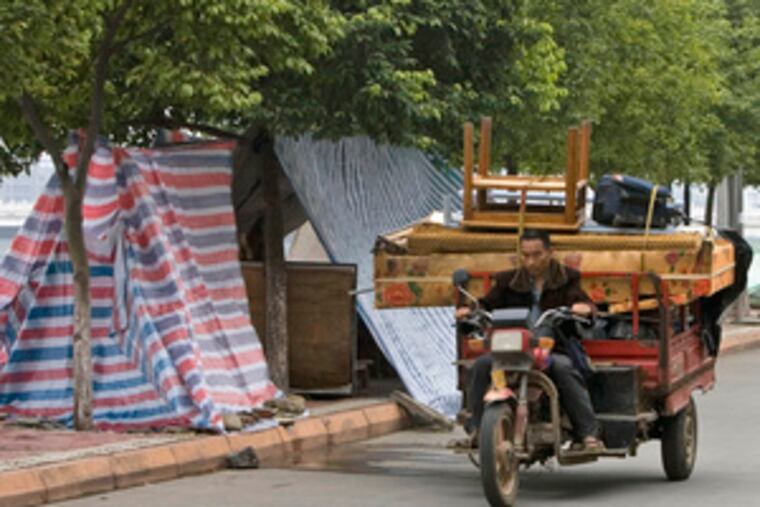 Evacuees in China brought their belongings back closer to home after being allowed to return yesterday. They had been displaced by a lake formed by the May earthquake.