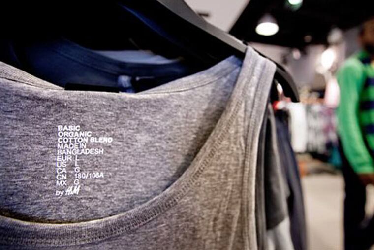 FILE - In this Dec. 12, 2012 file photo, a tank-top made in Bangladesh hangs on a rack in an H&M store in Atlanta. The rising death toll from the building collapse that killed more than 1,000 garment workers in Bangladesh on April 24, 2013 may force Western brands to make a choice. David Goldman
