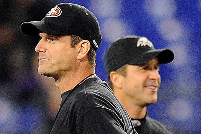 49ers head coach Jim Harbaugh, foreground, stands alongside his brother, Ravens head coach John Harbaugh, before an NFL football game. (Nick Wass/AP file photo)