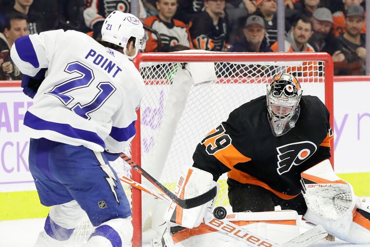 Flyers goaltender Carter Hart stops the puck against Tampa Bay Lightning center Brayden Point during the second period on Thursday, November 18, 2021 in Philadelphia.