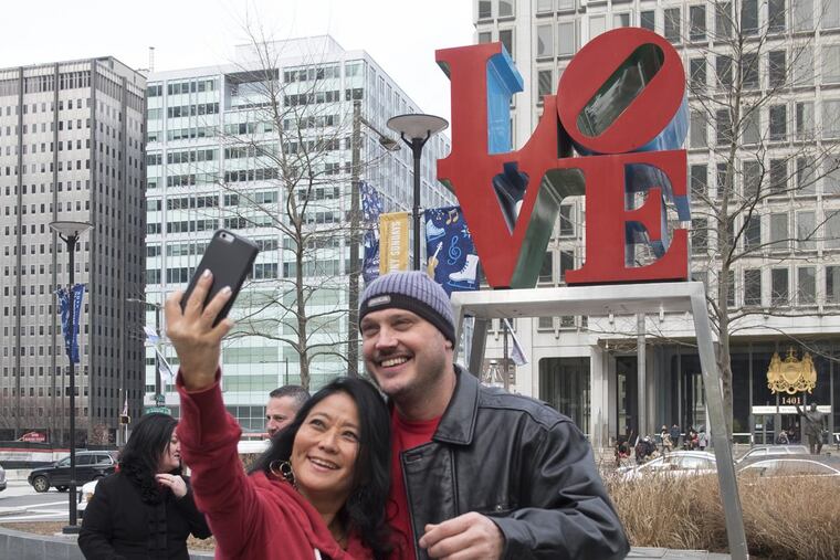 Faye Takata, 50 from Hawaii and Ben Mitchell, 47, of London celebrate their engagement while visiting Dilworth Park and Philadelphia. They took advantage of moderate temperatures and clear skies to get in last minute selfies in front of the iconic Love Statue Tuesday, February 14, 2017 just hours before the sculpture was scheduled to be removed for restoration