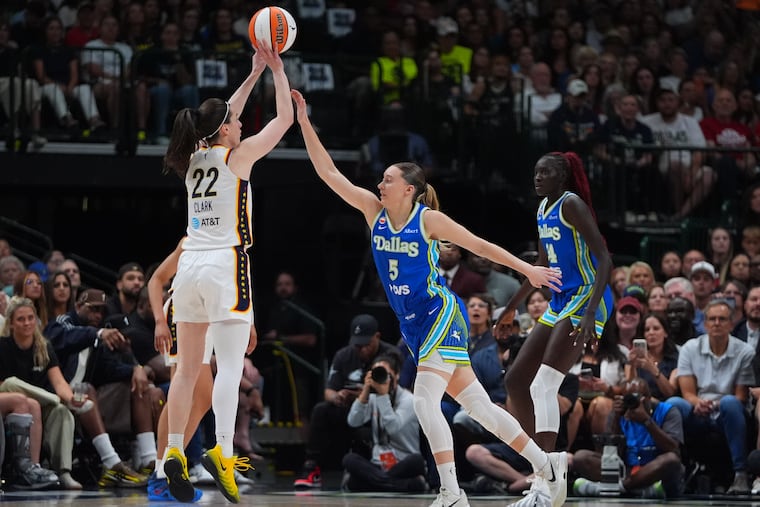 The Indiana Fever's Caitlin Clark in one of her new colorway shoe designs, shooting over the Dallas Wings' Paige Bueckers.