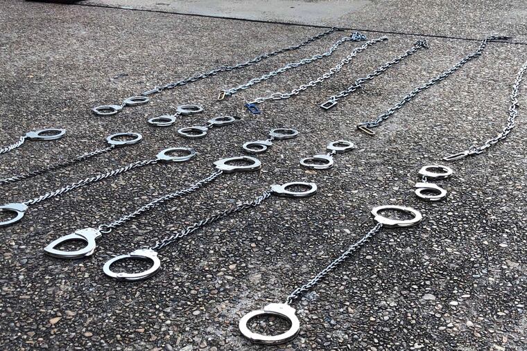 Shackles lie on the tarmac at an airfield in Alexandria, Louisiana, after ICE agents loaded deportees onto a flight to Guatemala. Handcuffs are typically removed from Guatemalan deportees about an hour before their flight lands, according to ICE. Leg restraints are removed when deportees board the plane.
