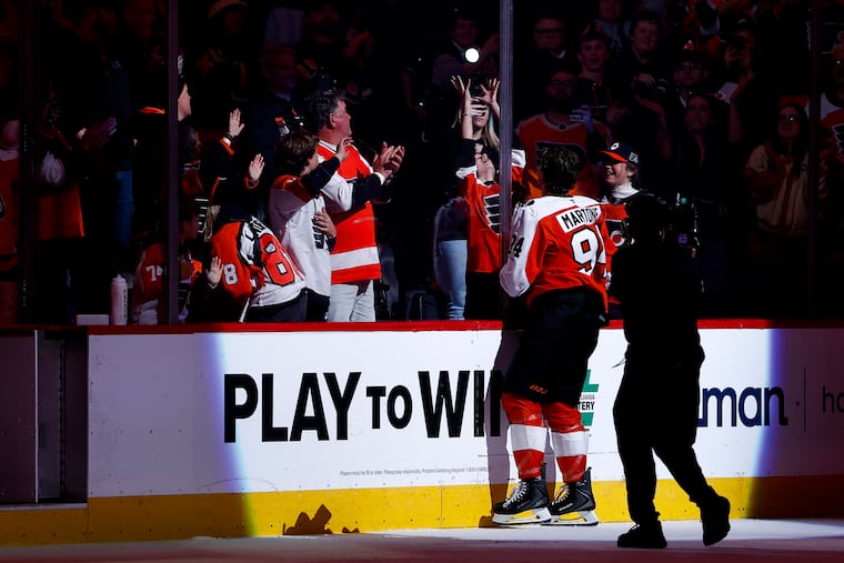 Rookie Porter Martone tosses a signed puck to 16-year-old Julianna Brogan after the Flyers beat the Bruins in overtime on Sunday.