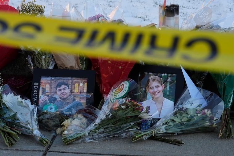 Photos of Brown University shooting victims Mukhammad Aziz Umurzokov and Ella Cook are seen among flowers at a makeshift memorial outside the Engineering Research Center on Tuesday.