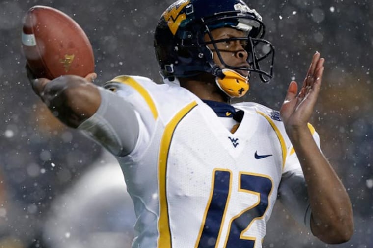 Geno Smith passes in the snow against Syracuse during the second quarter of the Pinstripe Bowl NCAA college football game at Yankee Stadium in New York, Saturday, Dec. 29, 2012. (Kathy Willens/AP)