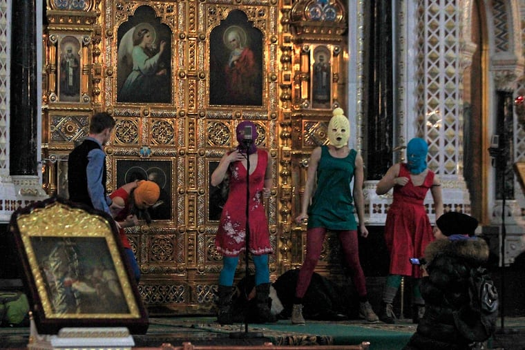 Members of the Russian feminist group Pussy Riot protest inside the Christ the Savior Cathedral in Moscow, Tuesday, Feb. 21, 2012.